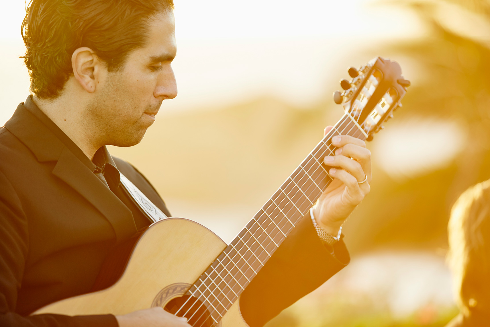 Musician plays guitar at sunset on Studio lawn at Montage Resort, Laguna Beach