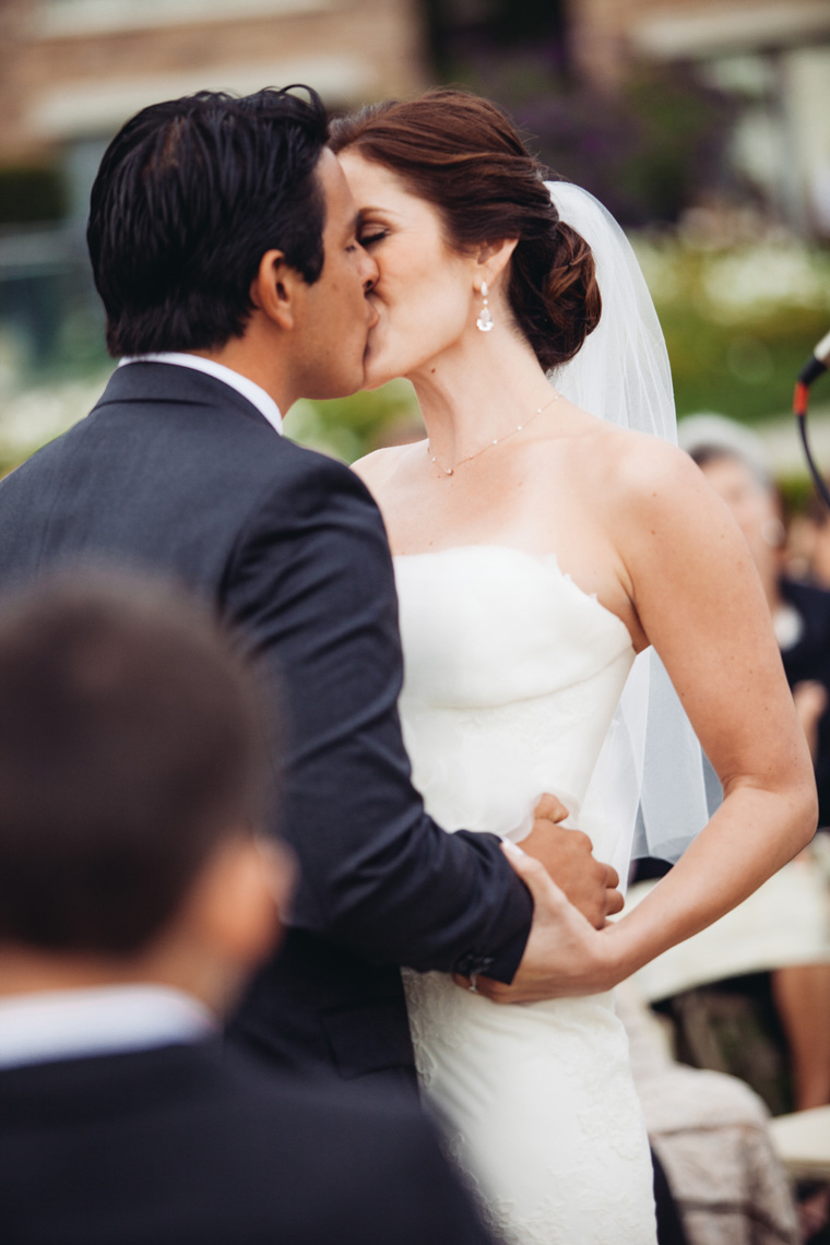 Bride and groom kiss during wedding ceremony on the Pacific Lawn at Montage Resort, Laguna Beach.